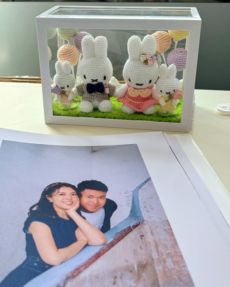 一個透明展示盒內的微縮鉤織作品，場景是草地上的Miffy一家人，包含穿禮服的新郎新娘及花童，全部使用極細的蕾絲線鉤織而成。