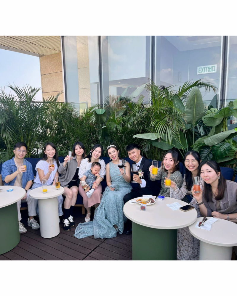 唧唧工作室的「唧公會」成員與身穿綠色晚裝的新娘Heyman在戶外露台舉杯慶祝的合照。